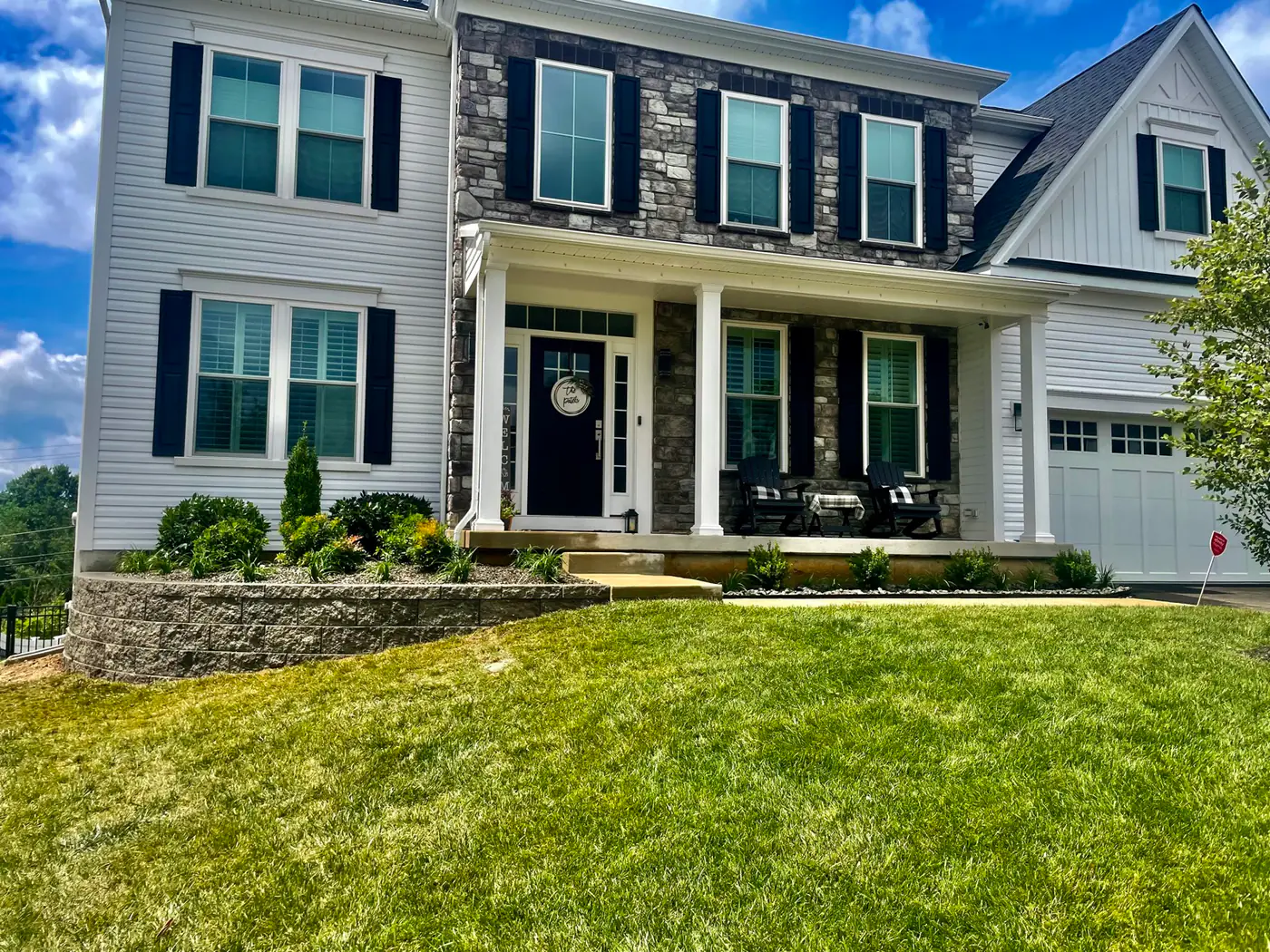 Stone-front home with a healthy established lawn