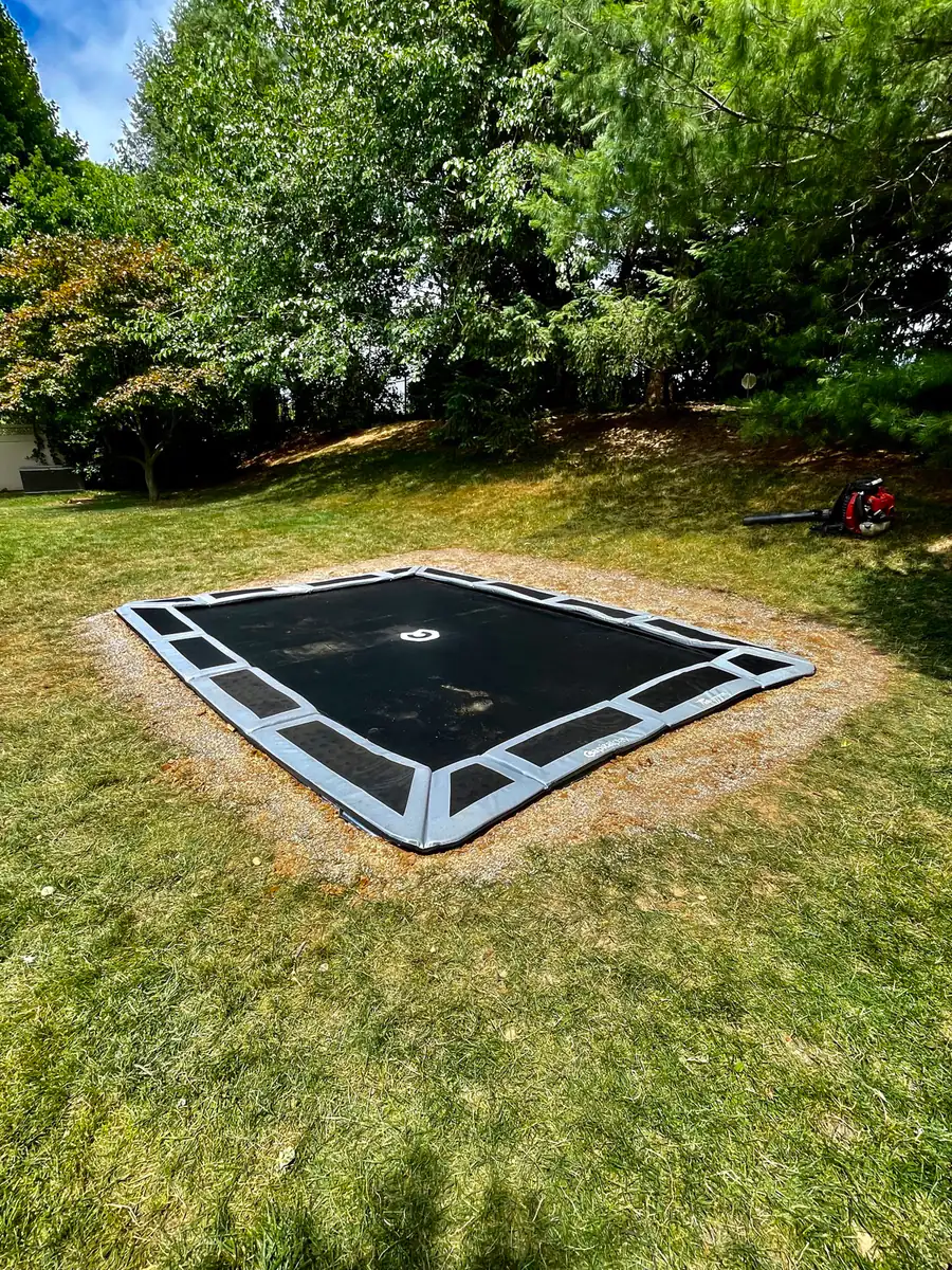 Inground trampoline in an open lawn